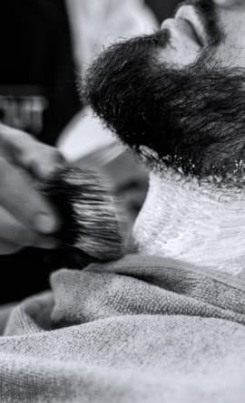 A barber, shaving clients neck